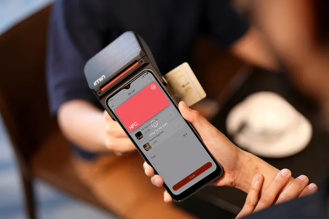Close-up of a smartphone using NFC for a contactless payment at a terminal. Payment processing commitments in a POS deal